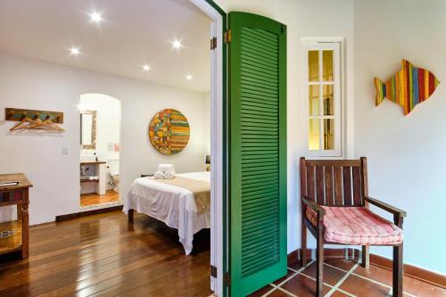 a room with a bed and a chair and a table at Boutique Hotel Carpe Diem in Paraty