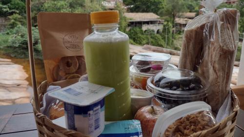 a basket with a bottle of green juice and some food at Pousada Serra Grisante in Lençóis