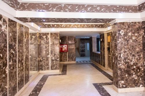 a hallway of a building with marble walls and floors at Cairo Heliopolis Apartment in Cairo