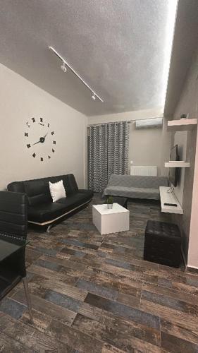 a living room with a couch and a clock on the wall at Vivian House in Thessaloniki