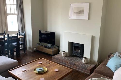 a living room with a coffee table and a fireplace at Lovely 4 bedroom home, stones throw from the beach in Brighton & Hove
