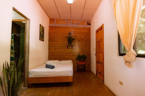 a small room with a bed and a mirror at Hostel Villa Vento Surf in Santa Catalina