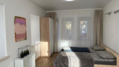 a bedroom with a bed and a window at Japandi apartamentai in Kaunas