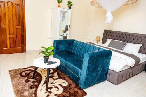a living room with a blue couch and a bed at Luxury Studio @ Twiga House in Kigali