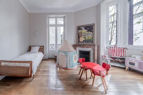 une chambre avec un lit, une table et une cheminée dans l'établissement La Maison Rouge - Maison Familiale & Proche centre, à Vichy