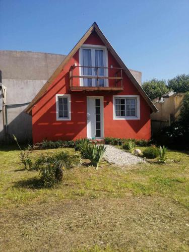 馬德普拉塔的住宿－Casa Alpina Mar del plata，红色的房子,上面设有阳台