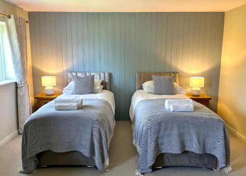 a bedroom with two beds with towels on them at The Manor at Abberley in Abberley