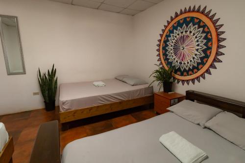 a room with two beds and a picture on the wall at Hostel Villa Vento Surf in Santa Catalina