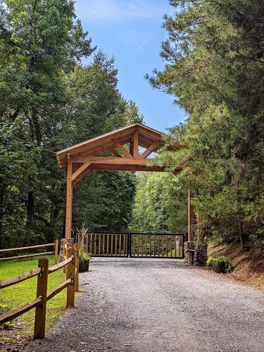 a wooden gate on a road next to a fence at Creek Crest Cabin Ocoee Riverside Cabin in Ocoee