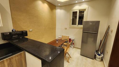 a kitchen with a black counter top and a refrigerator at 3rd floor luxury apartment-families only in Alexandria