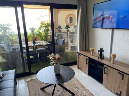 un soggiorno con tavolo e TV di BY NEPTUNE - la Palme Riviera Beach and Pool view a Cannes
