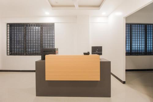 Sakthi Grand في إرود: وجود مكتب استقبال في غرفة فارغة مع وجود نافذتين