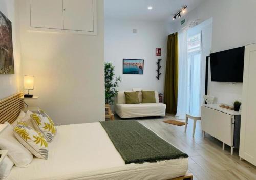 - une chambre avec un grand lit blanc et un canapé dans l'établissement (J3) Apartamento céntrico en Madrid, à Madrid