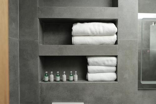 un montón de toallas en un estante en un baño en Vetus Hotel en Pristina