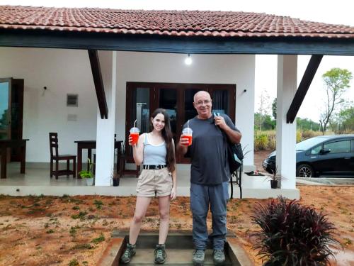a man and a woman standing in front of a house at MONI FARM HOUSE WILPATTU in Nochchiyagama