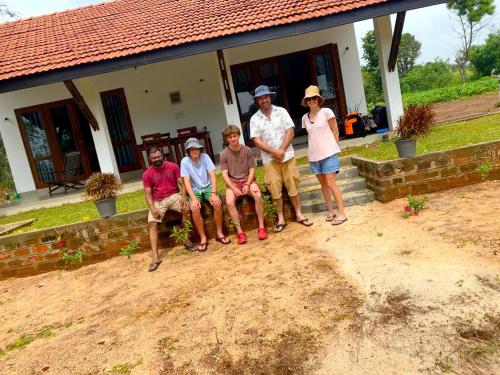 a group of people sitting in front of a house at MONI FARM HOUSE WILPATTU in Nochchiyagama