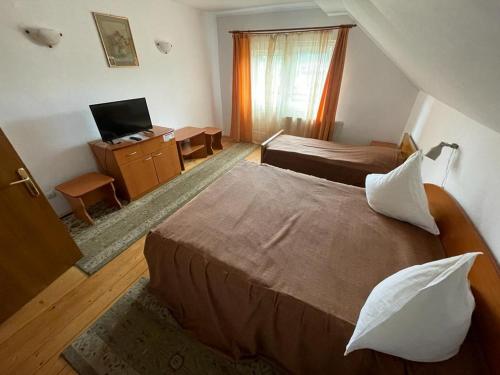 1 dormitorio con 1 cama y escritorio con ordenador en Pensiunea Genţiana, en Vatra Dornei