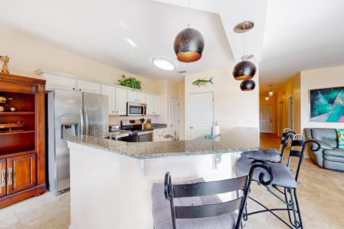 a kitchen with a counter with chairs and a counter top at Barataria 204 in Destin