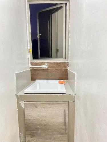 a bathroom with a sink and a mirror at Acogedor Apartamento Cercano al Aeropuerto Ernesto Cortissoz in Malambo