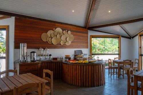 una cocina con paredes de madera y una barra con comida. en Flamingo Beach - Rede Soberano, en Porto Seguro
