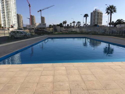 a large swimming pool in a city with tall buildings at Amplio dpto a pasos de la playa. in Coquimbo