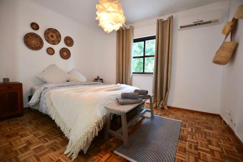 a bedroom with a bed and a table and a window at Apartamento Aperitivo in Tavira