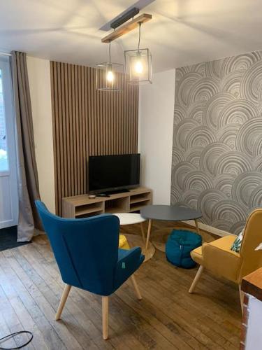 un salon avec une télévision, une table et des chaises dans l'établissement Appartement avec terrasse 2, à Gien
