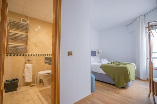 a bedroom with a bed and a shower and a toilet at Edificio Leganitos in Madrid