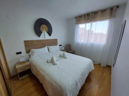 a bedroom with a white bed with two pillows on it at APARTAMENTO PLAZA DEL AYUNTAMIENTO con PARKING in Linares