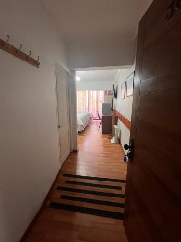 a hallway with a room with a bed and a door at NEW HOTEL CRUZ DEL SUR in Concepción