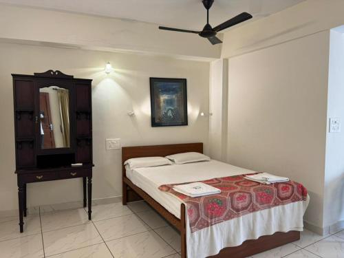 a bedroom with a bed and a dresser and a mirror at Aambal Residency in Cochin
