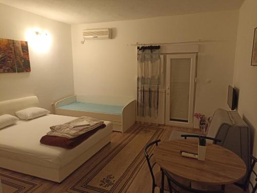 Kleines Zimmer mit einem Bett und einem Tisch in der Unterkunft Apartments Aldi in Mostar