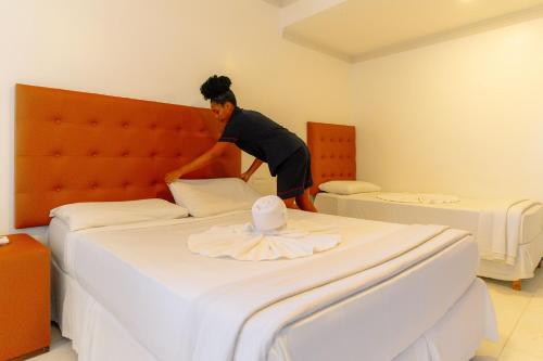 a man jumping on a bed in a hotel room at Shangrilá - Rede Soberano in Porto Seguro
