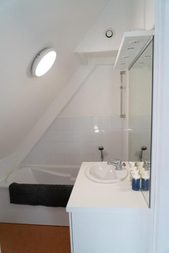 une salle de bain avec un lavabo et une baignoire dans l'établissement La maison sur la place, à Saint-André