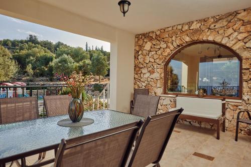 een eetkamer met een tafel en stoelen en een balkon bij Jessica Luxury Villa in Agios Nikolaos