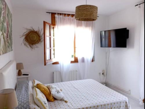 Un dormitorio con una cama con almohadas. en Casa en Castelldefels a 5 min de la playa, en Castelldefels