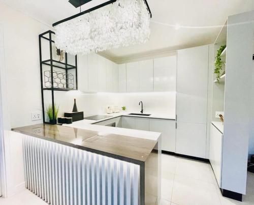 a white kitchen with a sink and a counter top at Hyde Park Sandton Luxury 2BR Top Floor in Johannesburg