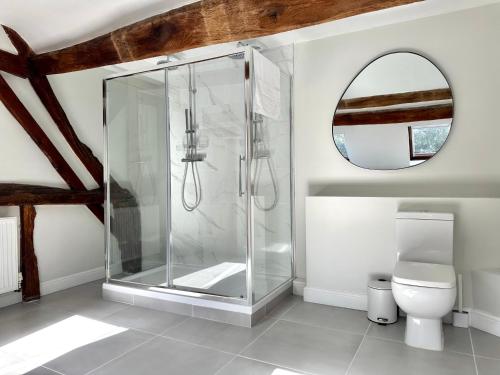 a bathroom with a shower with a toilet and a mirror at The Manor at Abberley in Abberley