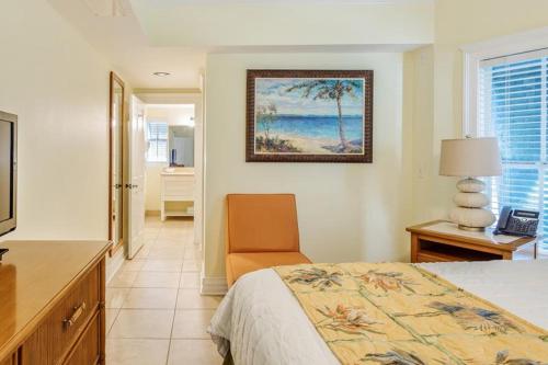 a bedroom with a bed and a desk and a chair at Coconut Beach Resort in Key West
