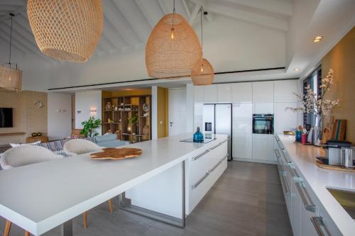 a kitchen with white cabinets and a large white island at Blue Bay Curaçao Golf & Beach Resort in Willemstad