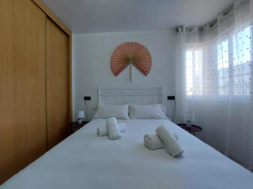 a bedroom with a large white bed with two pillows at Apartamento CentroLinares Con Parking in Linares