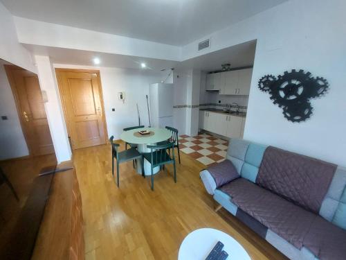 a living room with a couch and a table and a kitchen at Apartamento CentroLinares Con Parking in Linares
