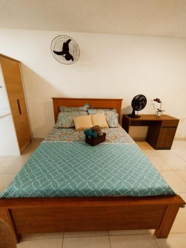 een slaapkamer met een bed en een klok aan de muur bij kitnet Praia do Morro Guarapari in Guarapari