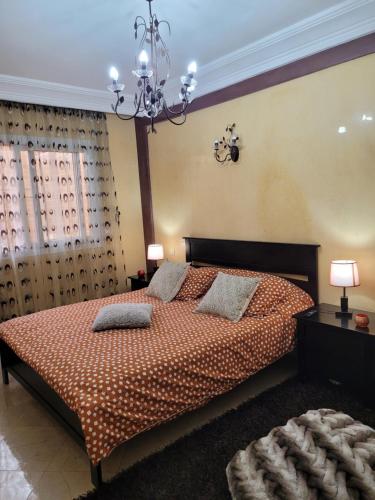 a bedroom with a bed and a chandelier at Cosy Dounia avec parking privatif in Casablanca