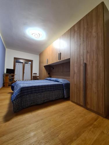 a bedroom with a bed and a large wooden cabinet at La Villetta di Oulx in Oulx