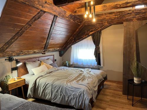 a bedroom with a large bed and wooden ceilings at Mushrooms Malomszállás in Tata