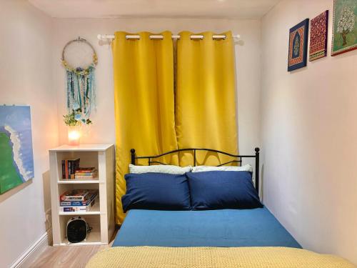 a bedroom with a bed with a yellow curtain at Liffey Valley Homestay in Dublin