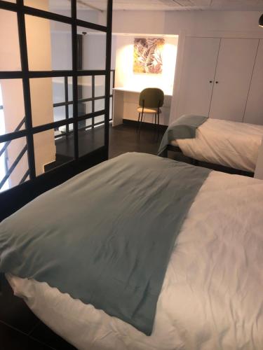 a bedroom with two beds and a desk with a chair at Loft 5 Maracena centro in Maracena