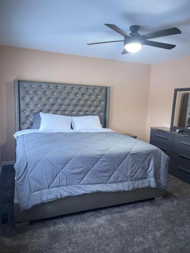 1 dormitorio con 1 cama y ventilador de techo en Beautiful 3 bedroom home, en Calgary