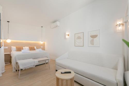 ein weißes Zimmer mit 2 Betten und einem Sofa in der Unterkunft Indulge Faustino 45-3 in Sevilla